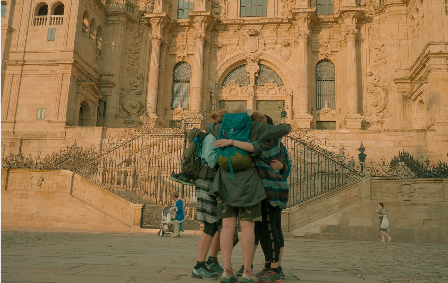 Three people hugging each other against the background of a historic palace