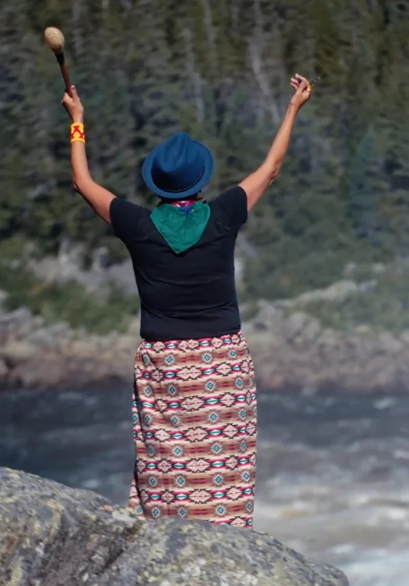 Shaman woman standing by the river